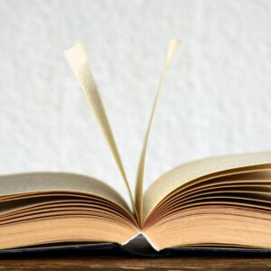 Close-up image of an open book with pages turning, creating a dynamic visual.